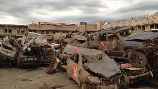Cars are piled up after a devastating tornado hits Moore, Oklahoma are marked with with spray paint after they were searched for victims.